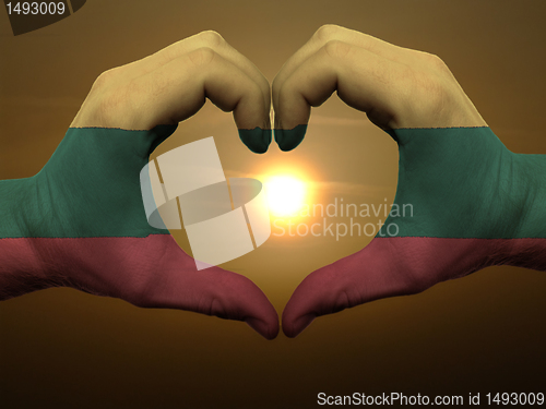 Image of Heart and love gesture by hands colored in lithuania flag during