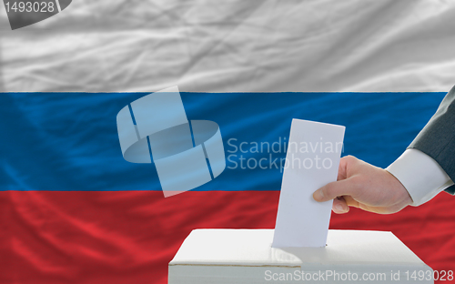 Image of man voting on elections in russia in front of flag