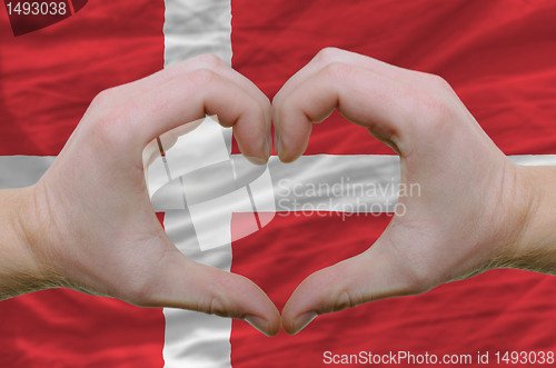 Image of Heart and love gesture showed by hands over flag of denmark back