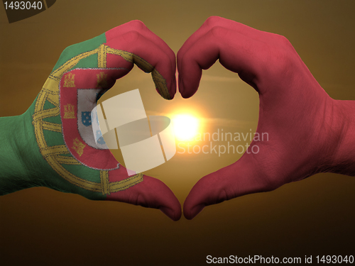 Image of Heart and love gesture by hands colored in portugal flag during 