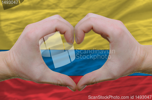 Image of Heart and love gesture showed by hands over flag of columbia bac