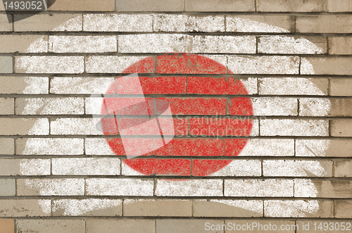 Image of flag of Japan on grunge brick wall painted with chalk  