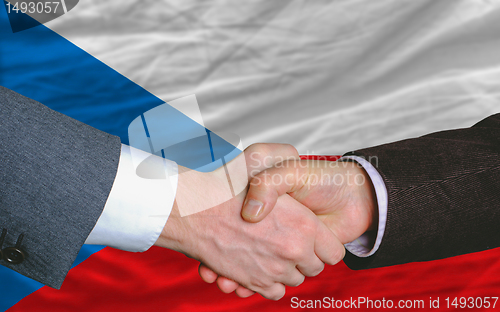 Image of businessmen handshake after good deal in front of czech flag