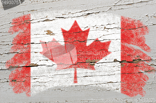 Image of flag of Canada on grunge wooden texture painted with chalk  