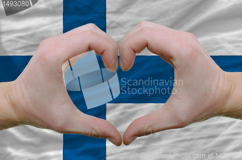 Image of Heart and love gesture showed by hands over flag of finland back