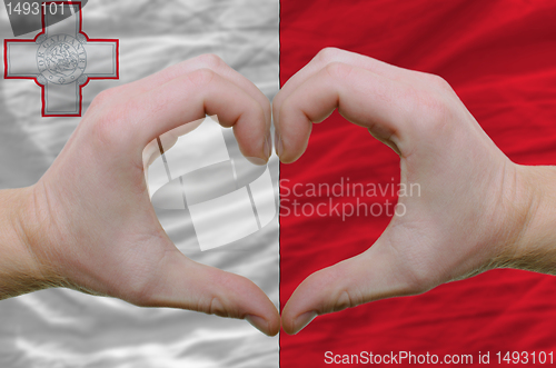 Image of Heart and love gesture showed by hands over flag of malta backgr