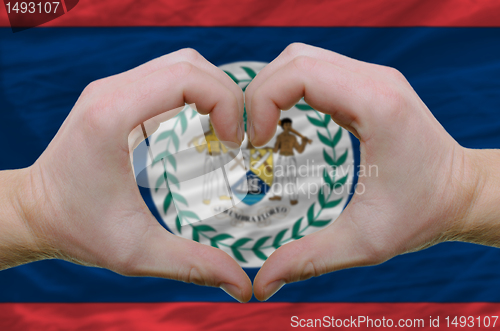 Image of Heart and love gesture showed by hands over flag of belize backg