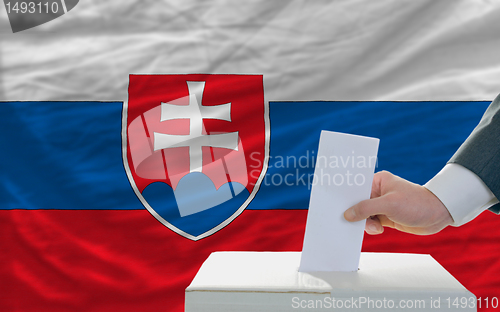 Image of man voting on elections in slovakia in front of flag