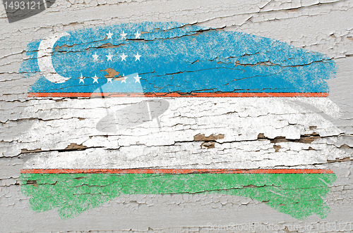 Image of flag of uzbekistan on grunge wooden texture painted with chalk  