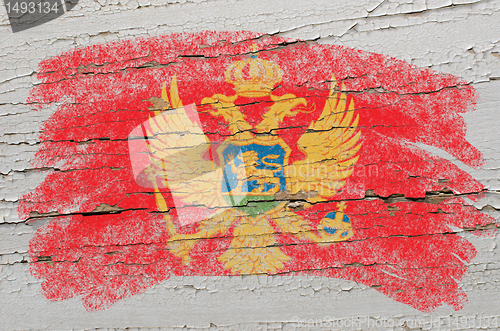 Image of flag of montenegro on grunge wooden texture painted with chalk  