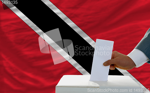 Image of man voting on elections in trinidad tobago in front of flag