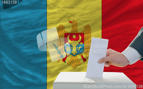 Image of man voting on elections in moldova in front of flag