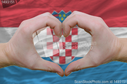 Image of Heart and love gesture showed by hands over flag of Croatia back