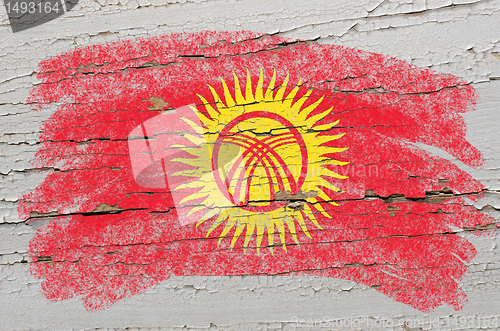 Image of flag of kyrghyzstan on grunge wooden texture painted with chalk 