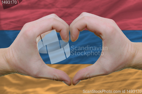 Image of Heart and love gesture showed by hands over flag of Armenia back