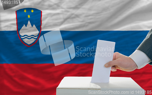 Image of man voting on elections in slovenia in front of flag