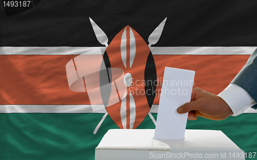 Image of man voting on elections in kenya in front of flag