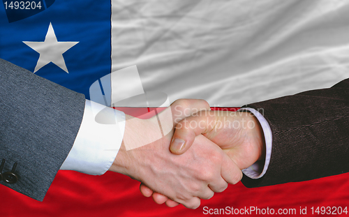 Image of businessmen handshakeafter good deal in front of chile flag