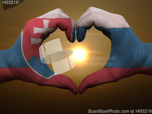 Image of Heart and love gesture by hands colored in slovakia flag during 