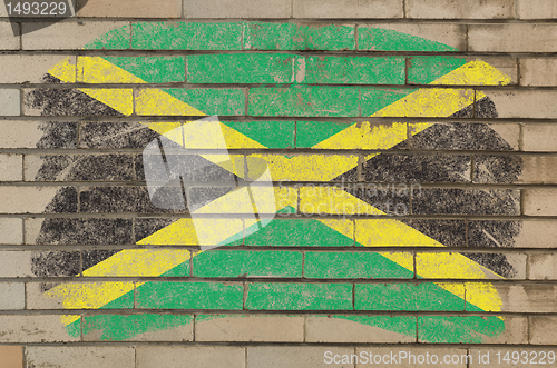 Image of flag of jamaica on grunge brick wall painted with chalk  