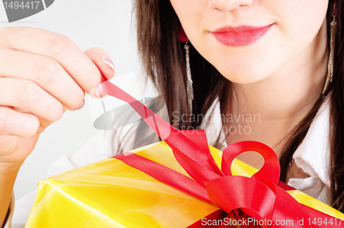 Image of Young girl opening present with smile