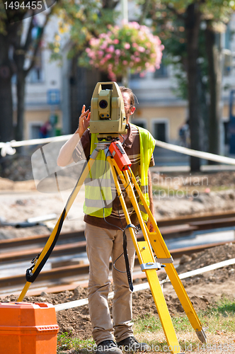 Image of Worker inspecting site  with his tripod and industrial device
