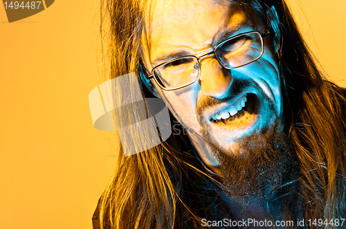 Image of Insane mad man against yellow background yelling