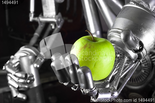 Image of Robot hand holding green apple
