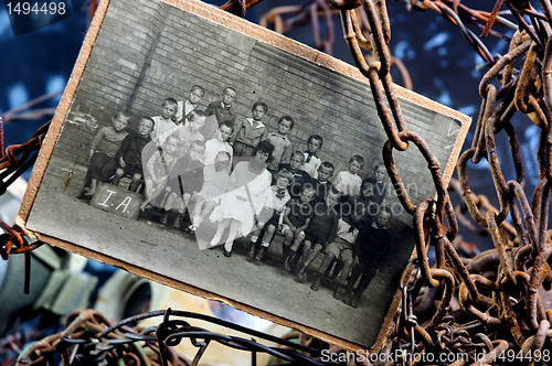 Image of Photo of sad children in a group between rusty chains