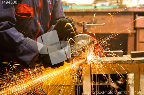 Image of Circular saw and a worker in a hard job