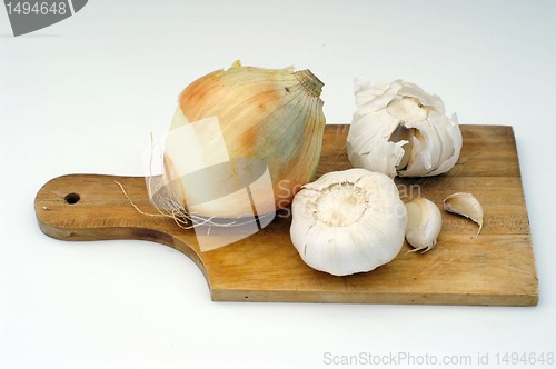 Image of Garlic and onion on a wooden plate