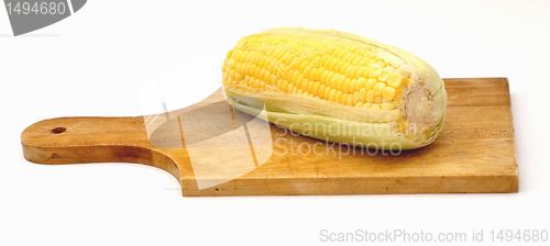 Image of A corn on a wooden plate