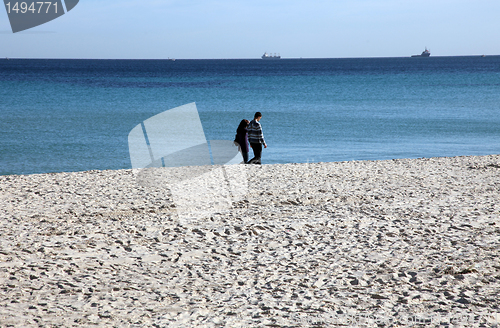 Image of Couple walking on the beach enjoying the vacation
