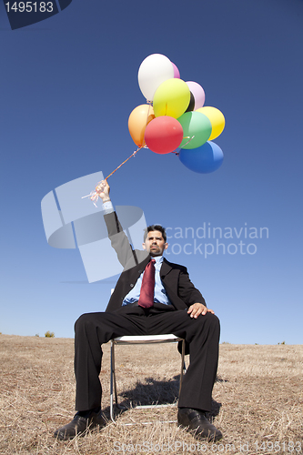 Image of Businessman in outdoor holding balloons