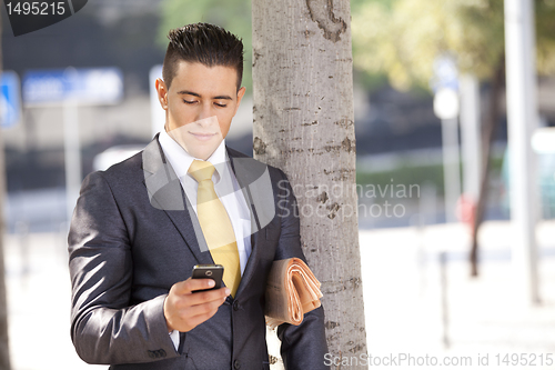 Image of Businessman sending messages in his cellphone
