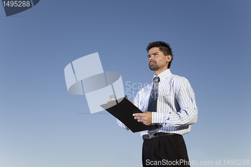 Image of Powerful businessman holding a notepad