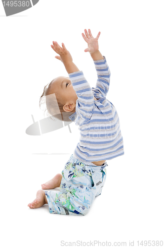 Image of cute little boy trying to catch something coming from the top, i