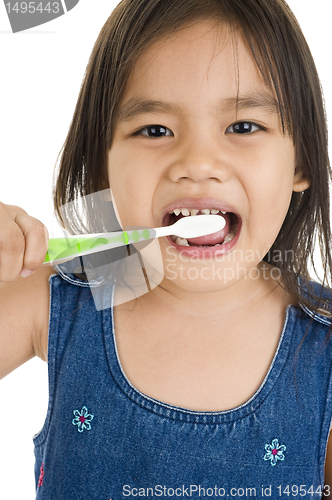 Image of little asian girl brushing her teeth