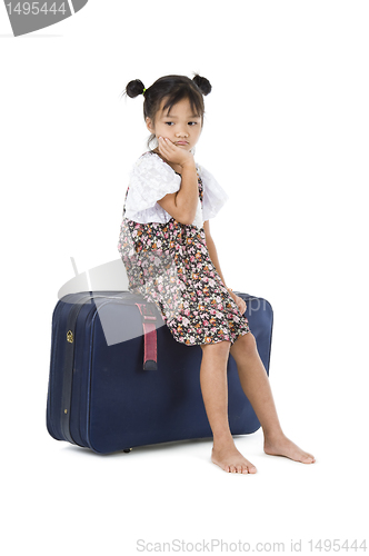 Image of bored Asian girl sitting luggage