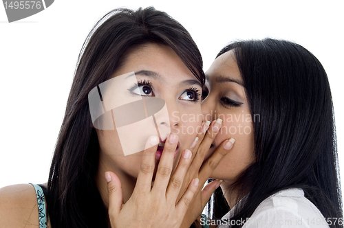 Image of woman telling her friend a secret