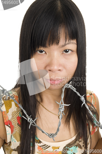 Image of Asian woman behind barbed wire