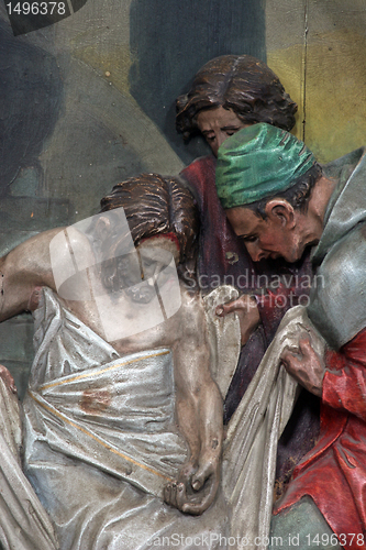 Image of 14th Stations of the Cross, Jesus is laid in the tomb and covered in incense