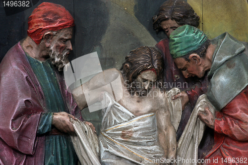Image of 14th Stations of the Cross, Jesus is laid in the tomb and covered in incense