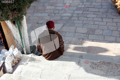 Image of The old man sitting on the stairs