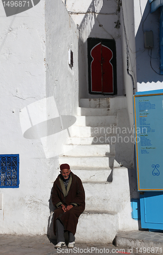 Image of The old man sitting on the stairs