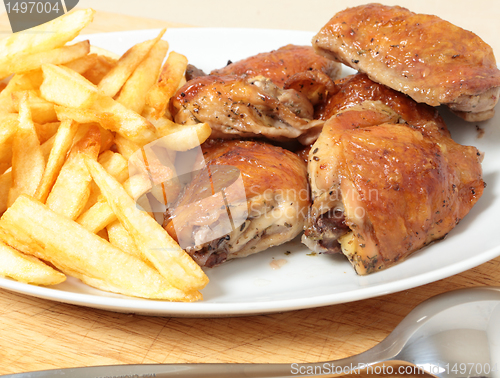 Image of Roast chicken thighs and fries with spoon