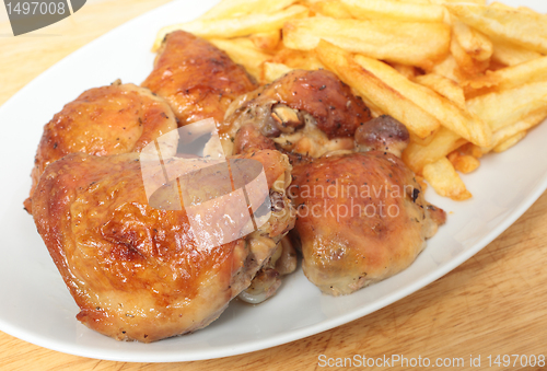 Image of Roast chicken thighs and fries with spoon