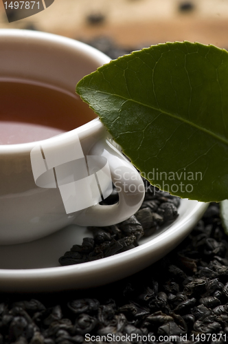 Image of A cup of green tea with freh leaves