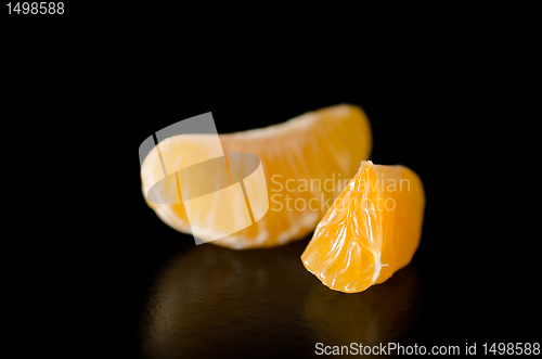 Image of Close up of a juicy Clementine orange slice on a black background.