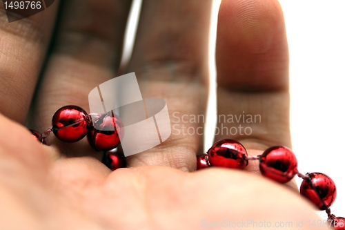 Image of hand with red pearls